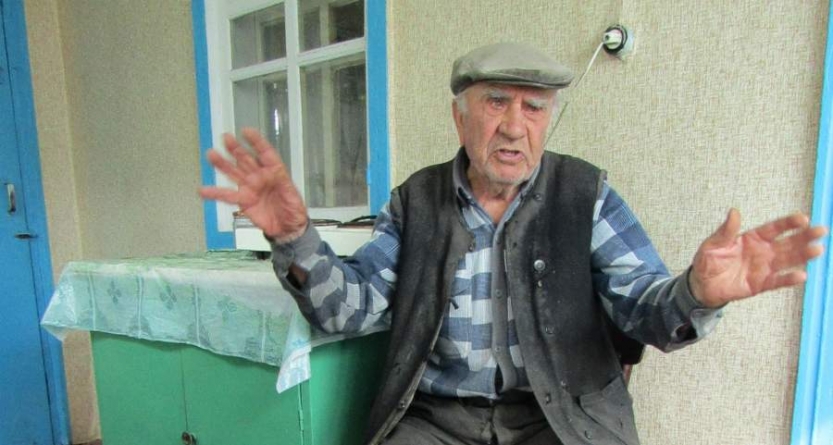 100-річний Денис Левіцький рубає дрова на зиму та читає газети